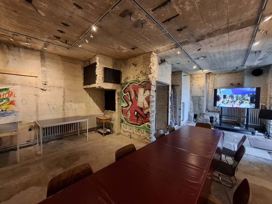 Rustikaler Konferenzraum mit langem Holztisch und Wandkunst im ehemaligen Bunkerinneren