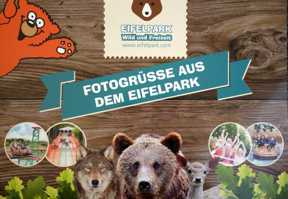 Ein buntes Fotowand-Schild mit Bären- und Tiermotiven begrüßt die Besucher im Eifelpark.