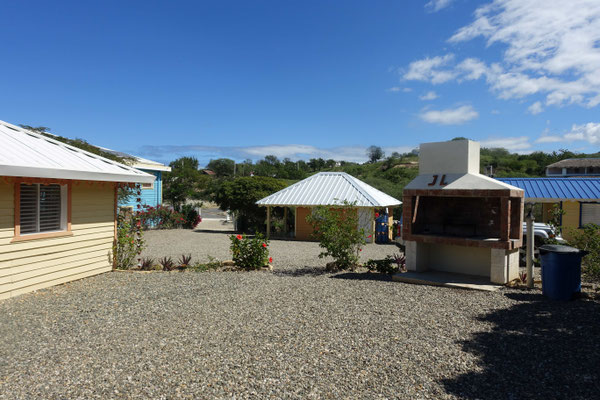 Le barbecue collectif et la maison du gardien au fond
