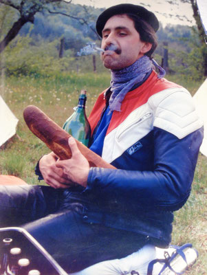 Motorradtreffen in Fronkraisch (La Brémendell): der Autor stilsicher gewandet mit Baskenmütze, Lederkombi in den französischen Nationalfarben und den Kennzeichen des gallischen Genussmenschen: Gauloises, Pinot Noir und Baguette [Foto: Robert Rösler]