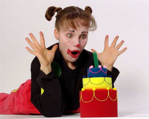 Clown Astrid staunt über einen Geburtstagskuchen