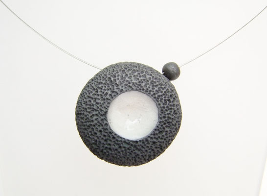 Pendentif en céramique raku noir et blanc avec effet pierre de lave vue en gros plan
