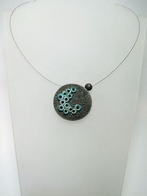 Pendentif sur collier en céramique noir et bleu vue de face