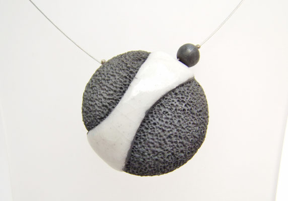 vue rapprochée d'une perle en céramique raku noire et blanche