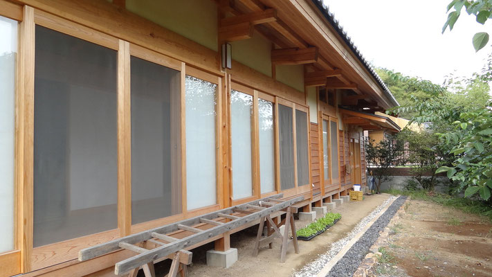 南外部の深い軒の出と木製建具。雨樋はなく雨落ちとした。