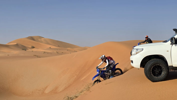 UN PILOTA ENDURO E UN VEICOLO DI SUPPORTO NELLE ALTE DUNE DEL RUB AL KHALI, OMAN