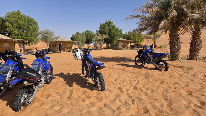 ENDURO MOTORBIKES AT CAMP WITH PALM TREES OMAN