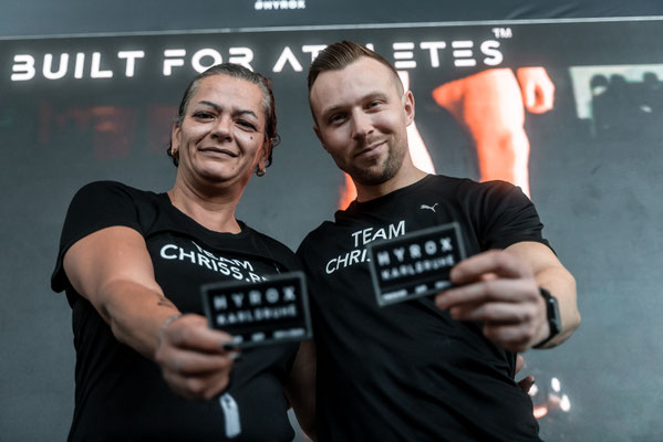 Christoph Wieloch (Personal Trainer Frankfurt & HYROX Coach) mit Sabine Bell bei HYROX Karlsruhe – Finisher-Karten nach strukturierter Wettkampfvorbereitung und Trainingsplan.