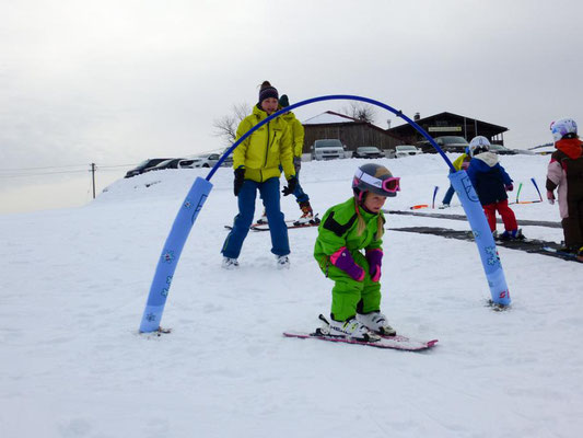 Kind fährt beim Zwergerl-Skikurs Skiteam Heufeld durch den Zauberbogen