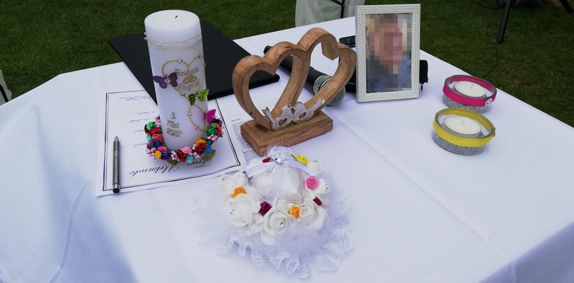 Auf einem Tisch stehen ein Bild zum Gedenken an einen Verstorbenen.