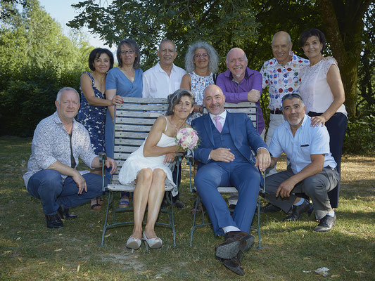 Mariage photo de groupe les mariés et leurs amis sur un banc 