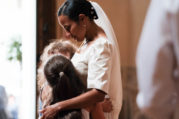 une mariée serre contre elle deux petites filles