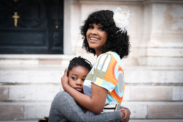 Femme noire, métisse, serre contre elle sa fille, qui l'enlace
