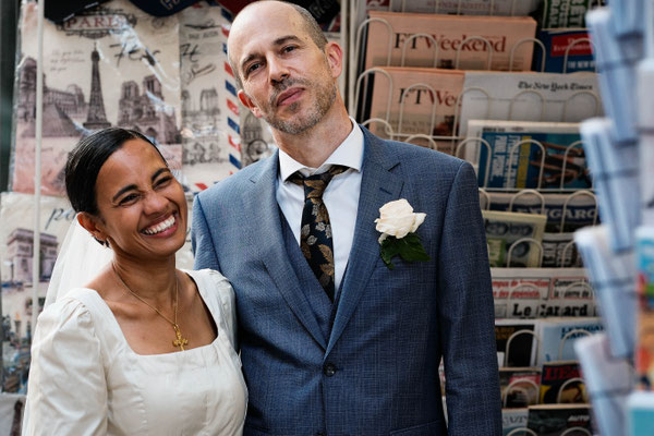 couple souriant devant un kiosque à journaux à Paris
