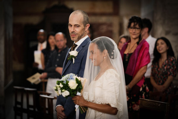 mariée sous un voile qui rejoint son mari