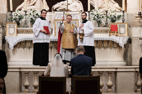 mariés de dos devant le prêtre qui les marie