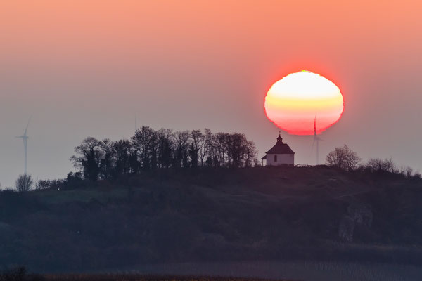 Sonnenaufgang hinter der Kleinen Kalmit - mit sehr seltenem "Grünen Strahl" oberhalb der Sonnenscheibe