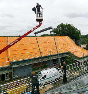 Montage von außenliegendem Sonnenschutz auf dem Dach einer umgebauten Scheune