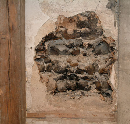 Stark bis tief ins Mauerwerk hinein brandgeschwärzte Stelle im Erdgeschoss an der Innenwand gegen die Grosse Kirchgasse hin. Hier befand sich möglicherweise die offene Feuerstelle, wo das Badewasser aufgewärmt wurde. 