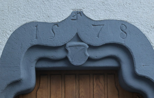 Portal von 1578 mit Wappen der Segesser: im Wappenschild eine Sense, auf Mundart Sägisse. Es handelt sich hier also um ein sogenanntes sprechendes Wappen.