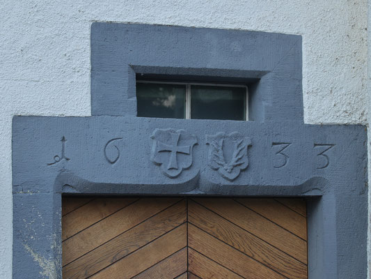 Links des Rundturms  Portal von 1633 mit den Wappen des Deutschen Ordens und von Heinrich Schenk von Castell, Leiter des Deutschordensritterhauses Beuggen.  Wohl zur gleichen Zeit erhielt der Iberghof eine wertvolle Innenausstatt im Stile der Renaissance.
