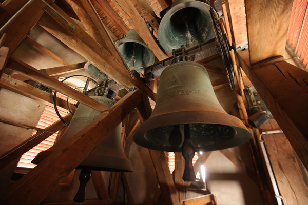 Die Glocken in der Glockenstube: oben von links: Schutzengel-, Hilaria- und Johannesglocke,  unten: Dreifaltigkeits- und Marienglocke. 