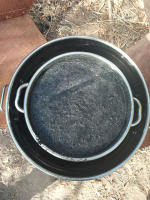 A propped up 50L stockpot inside a 100L stockpot. The central 50 litre stockpot is filled with water plus bamboo biochar from the SuperBoo TLUD floating on top for water filtration and a solar absober for steam generation