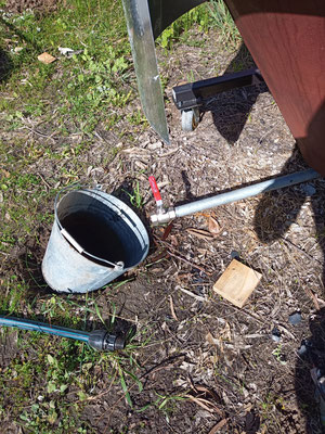 Draining the kiln the next day with a large bucket, dug in to a hole beneath the drain for more water per bucket, 'smoke water' transferred back to the IBC for the next burn