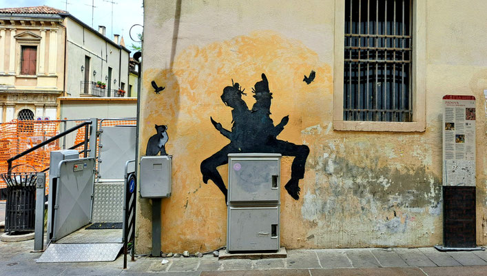 Streetart: Zwei Figuren Rücken an Rücken, die aufs Handy schauen