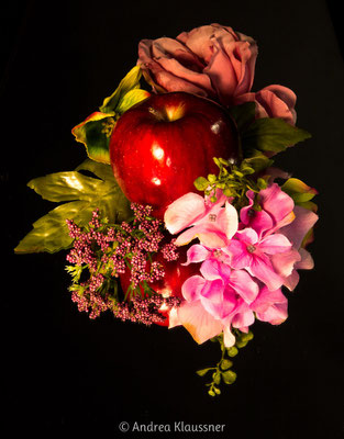 Ein Apfel, Dekoblumen, ein Spiegel und etwas "Spiellaune" sind die Zutaten zu diesem Bild.   /   An apple, plastic flowers, a mirror and a playful mood are the ingredients for this picture.