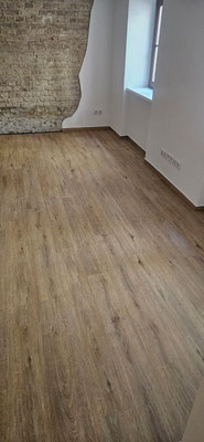 Stilvolles Zusammenspiel: Altbau mit Vinylboden in Holzoptik, historischem Backstein
