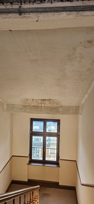 Vorher-Aufnahme des Altbau-Treppenhauses mit abgenutztem Geländer, vergilbten Wänden und renovierungsbedürftiger Decke.