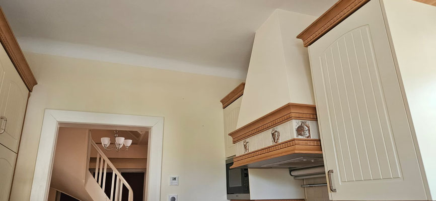 Renovierte Landhausküche mit freundlicher Farbgestaltung: Zarte Gelbtöne an den Wänden, weiße Decke und Rahmen.