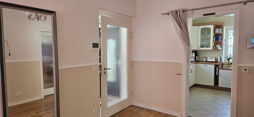 Einfamilienhaus nach Treppenhaus-Renovierung: helle, abgestimmte Wandfarben Beige und Creme, weiße Stuckleisten und wohnliches Parket