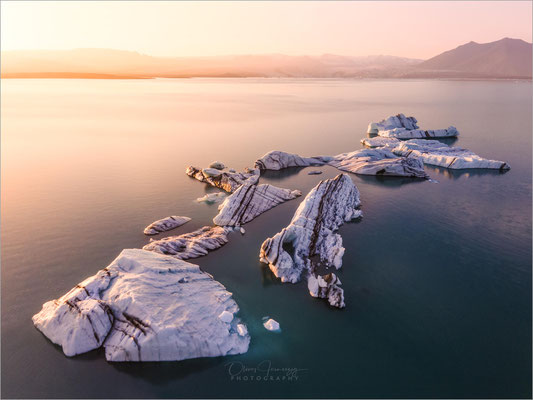 Jökulsárlón, die Gletscherlagune Islands, ist ein Naturwunder, das mit seiner Mischung aus schimmernden Eisbergen und tiefblauem Wasser verzaubert. Hier, wo Eis und Meer aufeinandertreffen, bietet sich ein atemberaubendes Schauspiel.