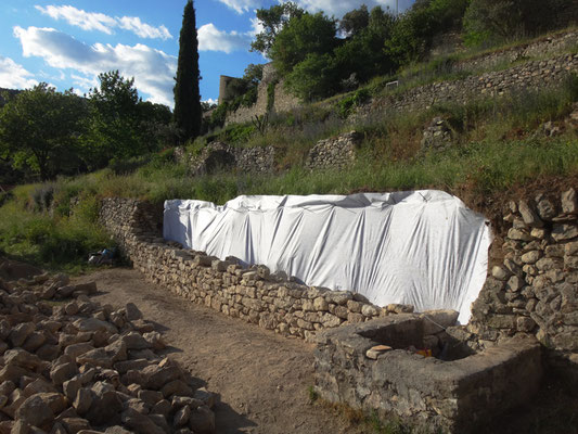 Premiers rangs assisés avec pose d'un géotextile en fond de parement. On remarque au premier plan un bassin qui sera réutilisé en approvisionnement eau