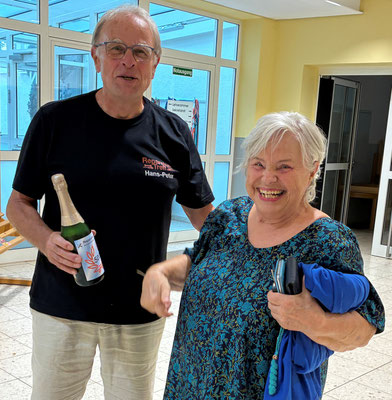 Hans-Peter überreich Frau Held eine Flasche Sekt