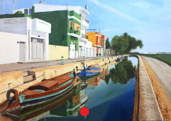 Canal de El Palmar con barcas amarradas, casas de colores reflejadas en el agua y cielo despejado.
