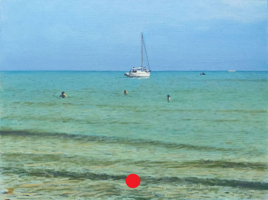 Velero fondeado frente a la playa con varios bañistas y mar en calma bajo un cielo despejado.