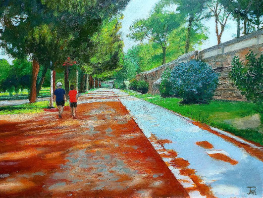 Camino arbolado del Jardín del Turia en el tramo de la Beneficencia, con dos personas caminando.