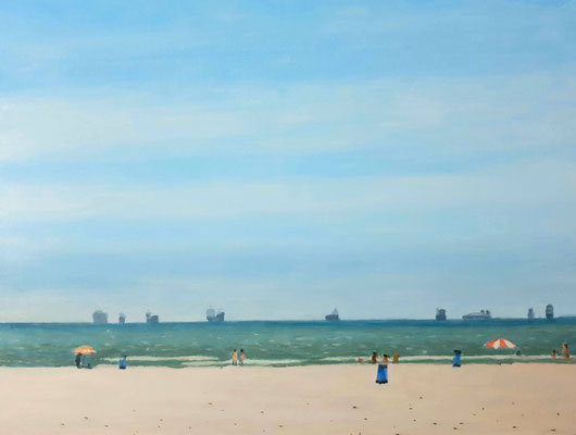 Playa de la Malvarrosa con bañistas dispersos y barcos en el horizonte vista desde el paseo marítimo.