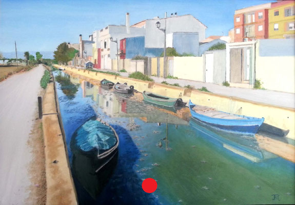 Canal de El Palmar con barcas amarradas, casas de colores y reflejos en el agua en un día despejado.