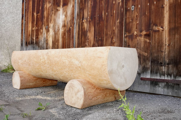 Detailansicht eines splintfreien Brunnentrogs aus Lärchen-Rundholz ohne Brunnenstock mit sichtbarer Fussauflage und Holzstruktur