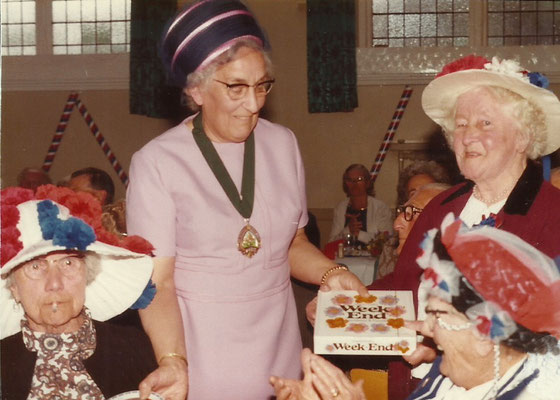Mrs. Dingley presents the prize to the winner of the hat competition.