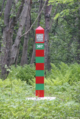 Großaufnahme des russischen Grenzpfahls in den Farben grün und rot am anderen Ufer des Jakobselva 