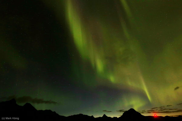 Grüne Nordlichter vor den Bergen nördlich von Svolvær, rechts die Europastraße E10 (Foto: ISO 800, Blende 5,6, 16 mm, 10 Sek.)