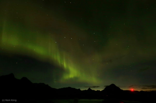 Grüne Nordlichter vor den Bergen nördlich von Svolvær, rechts die Europastraße E10 (Foto: ISO 800, Blende 2,8, 16 mm, 2 Sek.)