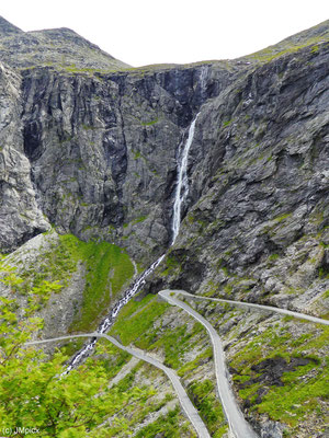 Die Pass-Straße Trollstigen erklimmt mit zahlreichen Serpentinen den Berg mit Wasserfall Stigfossen