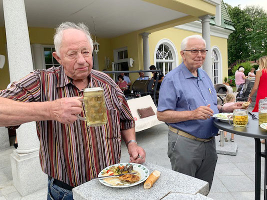 Zwei Männer bei einer kleinen Feier mit Bier und gutem Essen