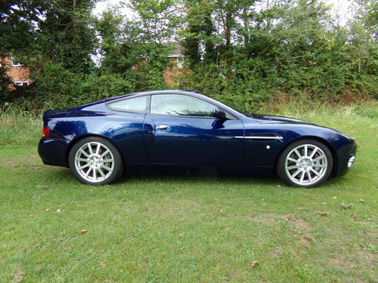 Side view of finished body repair work by Precision Paint on a blue Aston Martin Vanquish S